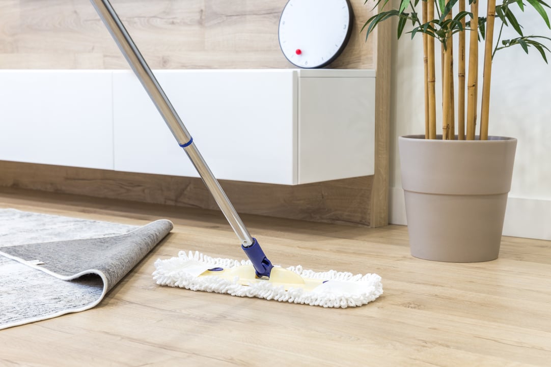 Wooden floor with white mop, cleaning service concept